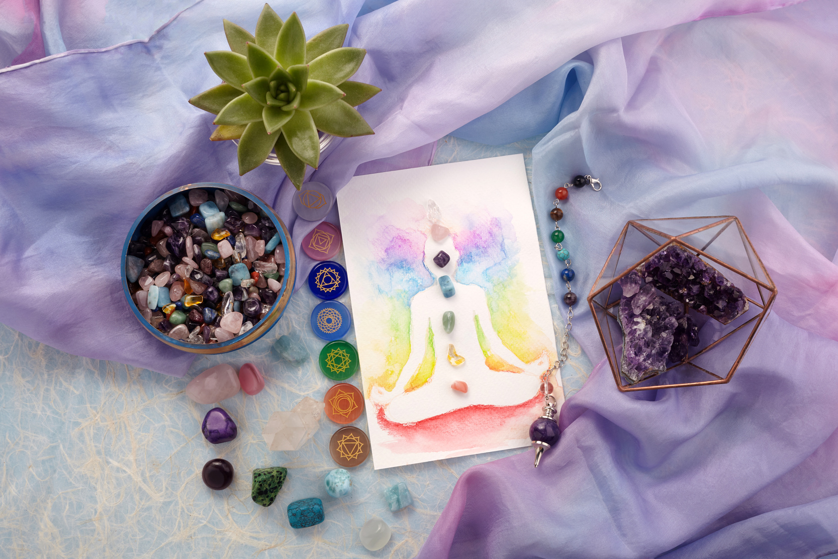 Natural crystals and pendulum on pastel silk background. Reiki background with card.
